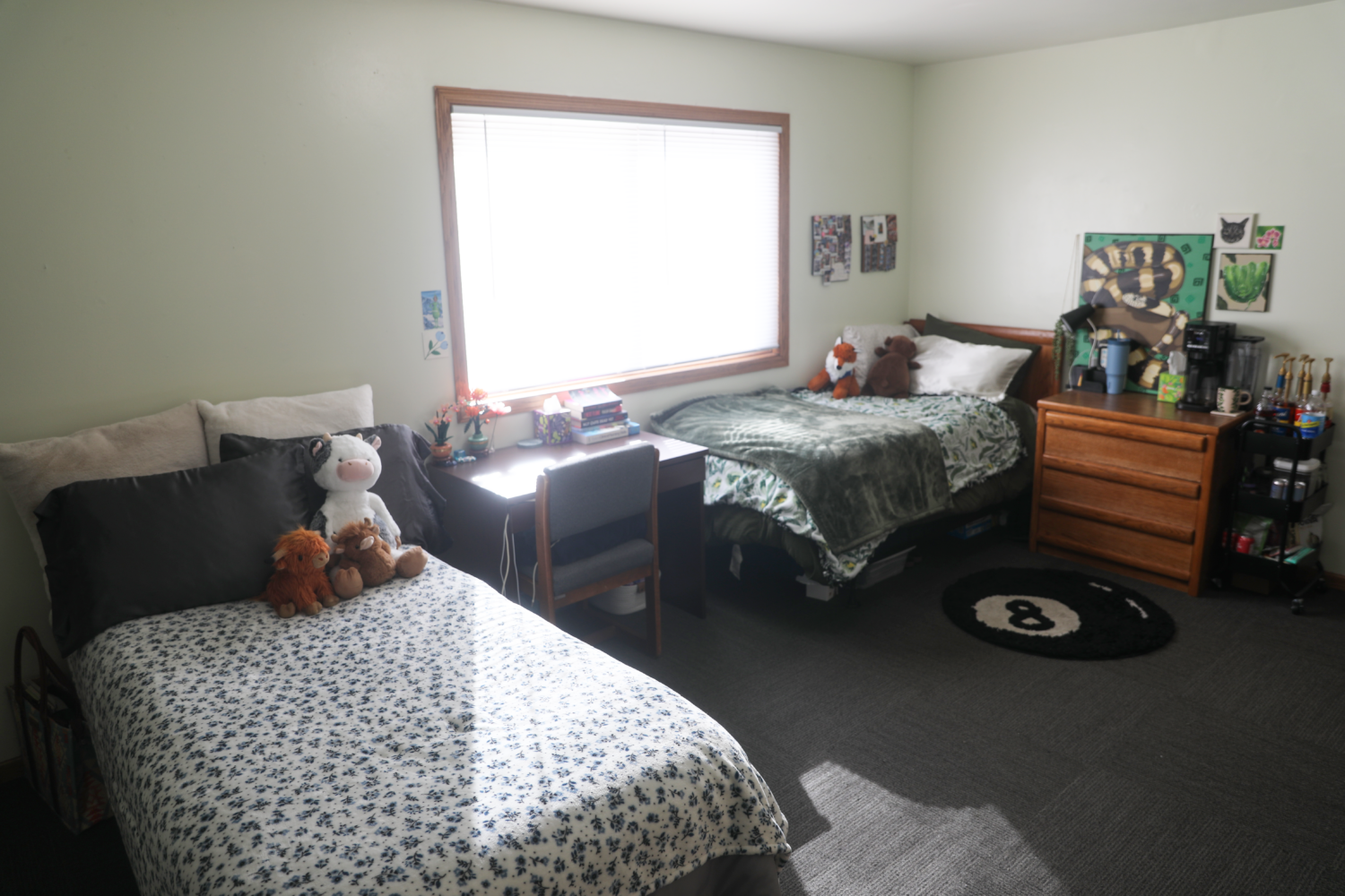 H31A0046 Bedroom with an 8-ball carpet, 2 different bed designs, a desk and dresser, and a drink cart.