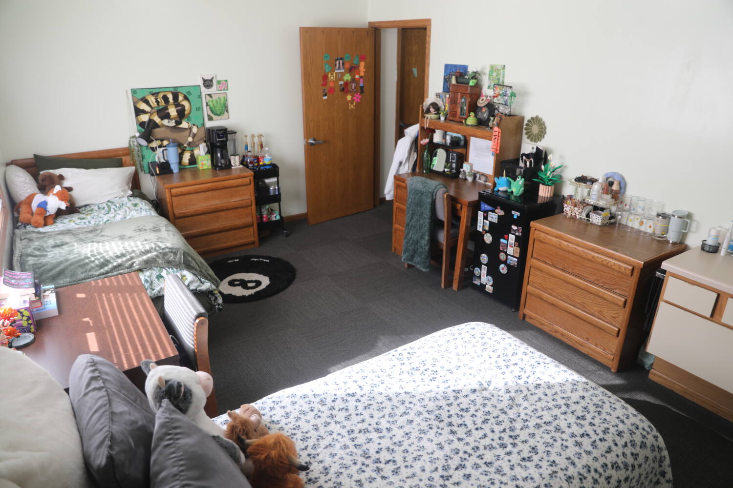 H31A0068 Bedroom with 2 dressers, 2 beds, 2 desks, and a mini fridge.