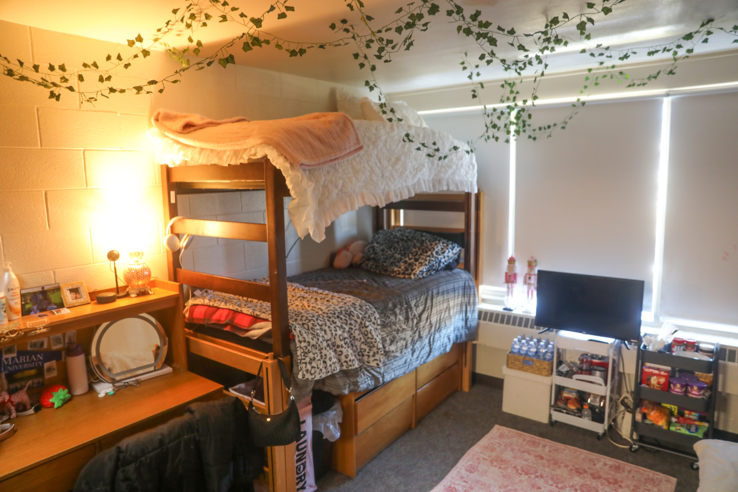 Dorm room with bunk beds, a tv, and a desk.